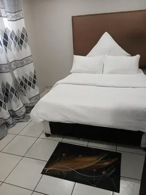 a bedroom with a bed and a fireplace in the floor at Thonta house in Pretoria