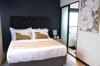 a bedroom with a large bed with a black headboard at Urban Oasis Retreat in Midrand in Midrand