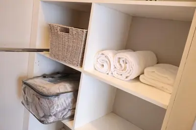 a closet with towels and a basket on a shelf at Urban Oasis Retreat in Midrand in Midrand