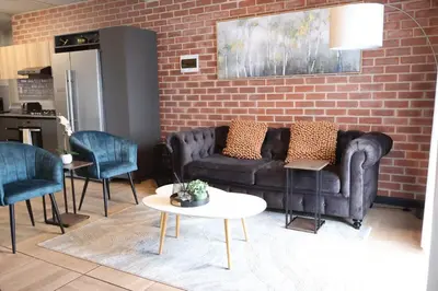 a living room with a couch and two chairs at Urban Oasis Retreat in Midrand in Midrand