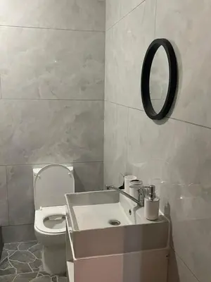 a bathroom with a toilet and a sink and a mirror at Tucked away with a pool view in White River