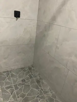 a bathroom with a shower with a tiled floor at Tucked away with a pool view in White River