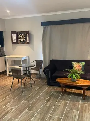 a living room with a couch and a table at Tucked away with a pool view in White River