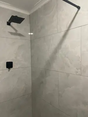 a bathroom with a shower with a tile wall at Tucked away with a pool view in White River