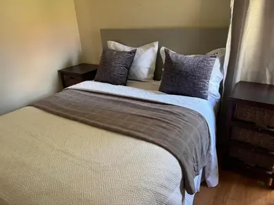 a bedroom with a large bed with pillows on it at Peshi's Guest House in Pretoria