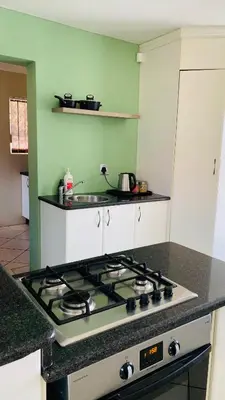 a kitchen with a stove top oven in a kitchen at Peshi's Guest House in Pretoria