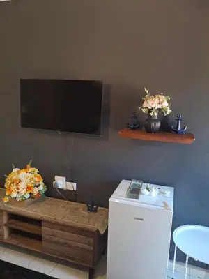 a living room with a tv and a table with flowers at The Private Location in Thohoyandou