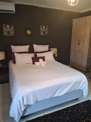 a large white bed with two stuffed animals on it at The Private Location in Thohoyandou