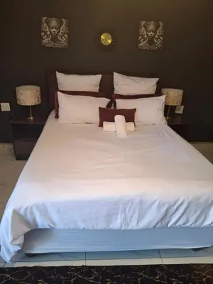 a large white bed with two towels on it at The Private Location in Thohoyandou