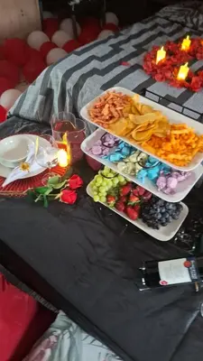 a black table with plates of food and candles at The Private Location in Thohoyandou