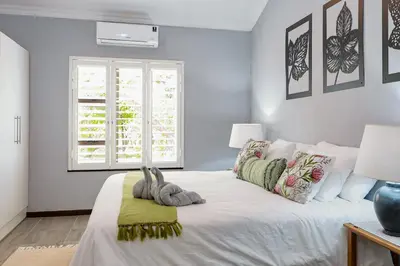 a bedroom with a large white bed with a window at Stripes & Sunsets Marloth Park - Self catering, Bush retreat With Pool & Wildlife views Near Kruger Park in Marloth Park