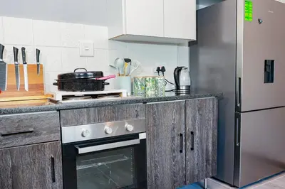 a kitchen with a stove and a refrigerator at Stripes & Sunsets Marloth Park - Self catering, Bush retreat With Pool & Wildlife views Near Kruger Park in Marloth Park