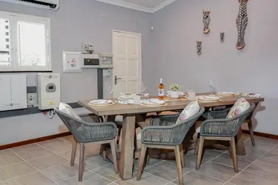 a dining room with a table and four chairs at Stripes & Sunsets Marloth Park - Self catering, Bush retreat With Pool & Wildlife views Near Kruger Park in Marloth Park