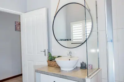 a bathroom with a sink and a mirror at Stripes & Sunsets Marloth Park - Self catering, Bush retreat With Pool & Wildlife views Near Kruger Park in Marloth Park
