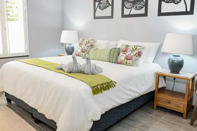 a bedroom with a bed with two stuffed animals on it at Stripes & Sunsets Marloth Park - Self catering, Bush retreat With Pool & Wildlife views Near Kruger Park in Marloth Park