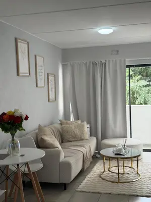 a living room with a couch and two tables at Elevare suites in Nelspruit