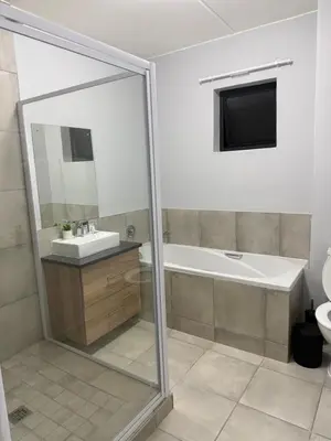 a bathroom with a tub and a sink and a toilet at Elevare suites in Nelspruit