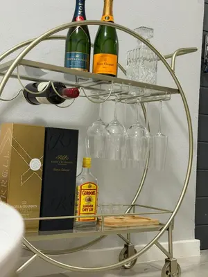 a metal wine rack with wine bottles and glasses at Elevare suites in Nelspruit