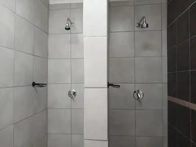 a shower with two shower heads in a bathroom at 41 on Clarendon in Graskop