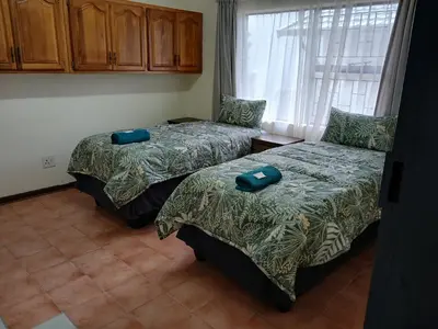 a bedroom with two beds and a window at 41 on Clarendon in Graskop
