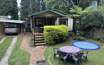 a patio with a table and chairs and a house at Cabin & Cottage Kaapsehoop in Kaapsehoop