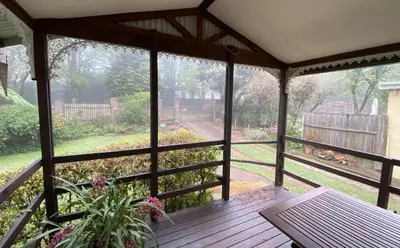 a screened in porch with a view of a garden at Cabin & Cottage Kaapsehoop in Kaapsehoop