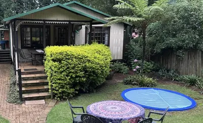 a patio with a table and chairs and a house at Cabin & Cottage Kaapsehoop in Kaapsehoop