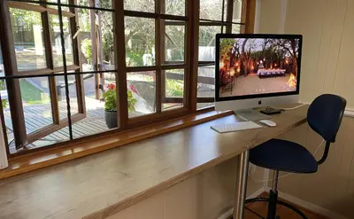 a computer monitor sitting on a desk next to a window at Cabin & Cottage Kaapsehoop in Kaapsehoop