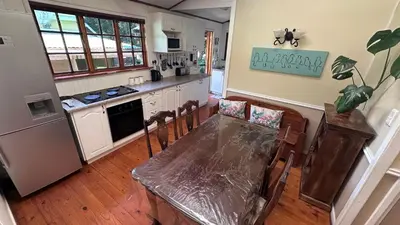 a kitchen with a table with chairs and a counter top at Cabin & Cottage Kaapsehoop in Kaapsehoop