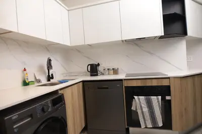 a kitchen with white cabinets and a dishwasher at Waterfall Munyaka Estate in Midrand