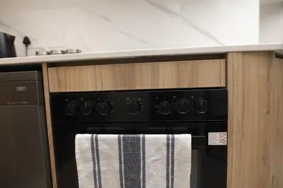 a black oven with a towel on it in a kitchen at Waterfall Munyaka Estate in Midrand