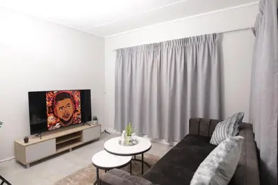 a living room with a couch and a tv at Waterfall Munyaka Estate in Midrand