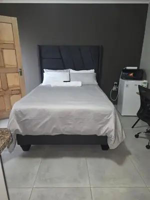 a bed with white sheets and pillows in a bedroom at The Good Samaritan 1 in Witbank