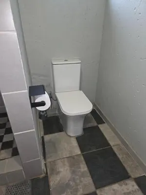a bathroom with a white toilet in a stall at The Good Samaritan 1 in Witbank