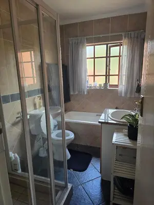 a bathroom with a toilet and a tub and a sink at Entire Home - Relax - Work - Entertain - Private in Centurion