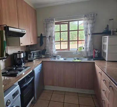 a kitchen with wooden cabinets and a sink and a window at Entire Home - Relax - Work - Entertain - Private in Centurion