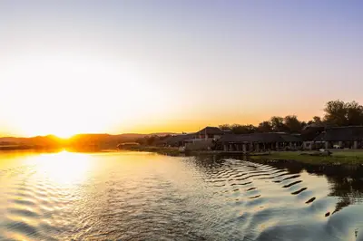 a sunset over a body of water with houses at Kambaku II Boat Safaris & Lodge in Phalaborwa