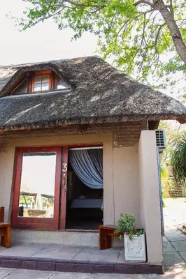 a small house with a thatched roof and a door at Kambaku II Boat Safaris & Lodge in Phalaborwa