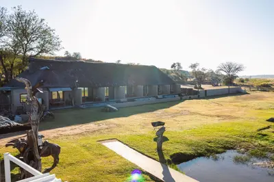 a house with a large yard with a pond at Kambaku II Boat Safaris & Lodge in Phalaborwa