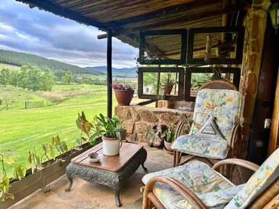 a patio with chairs and a table and a view at Gunyatoo Trout Trout Farm & Guest Lodge in Sabie