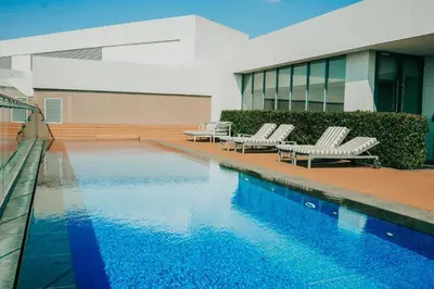 a swimming pool with two lounge chairs and a building at Menlyn Maine Trilogy Apartment 914A in Pretoria