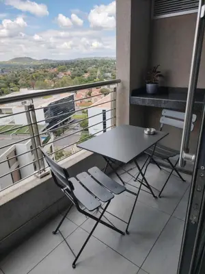 a table and chairs on a balcony with a view at Menlyn Maine Trilogy Apartment 914A in Pretoria