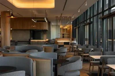 a restaurant with chairs and tables and windows at Radisson Hotel & Convention Center Steve Tshwete Middelburg in Middelburg