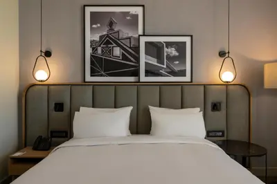 a bed in a hotel room with two pictures on the wall at Radisson Hotel & Convention Center Steve Tshwete Middelburg in Middelburg
