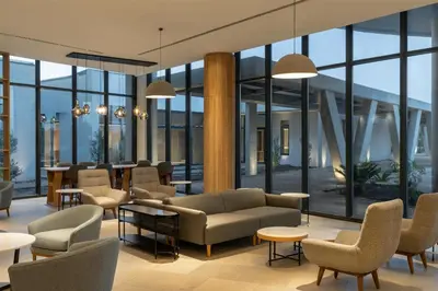 a lobby with couches and tables and windows at Radisson Hotel & Convention Center Steve Tshwete Middelburg in Middelburg