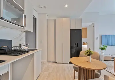 a kitchen and living room with a wooden table in a room at MNM Luxury Suit 424 in Pretoria