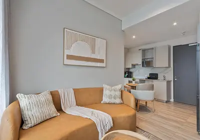 a living room with a couch and a kitchen at MNM Luxury Suit 424 in Pretoria