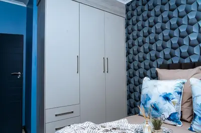 a bedroom with a bed with a blue wall at Modern 3-Bedroom Retreat Fully Equipped Comfort in Midrand