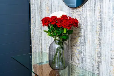 a vase filled with red roses on a wall at Modern 3-Bedroom Retreat Fully Equipped Comfort in Midrand