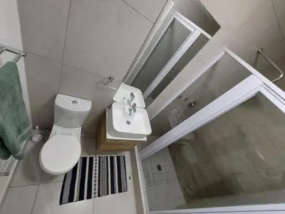 a bathroom with a toilet and a sink and a shower at Spacious 2 bedroom, 2 bathroom unit in Pretoria